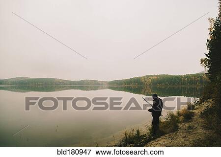 Man fishing in remote lake View Large Photo Image Stock Photo - Man fishing in remote lake. Fotosearch