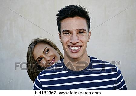 Stock Image - Man smiling with girlfriend outdoors. Fotosearch