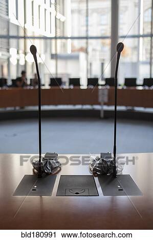 Stock Image - Microphones at desk in meeting room. Fotosearch