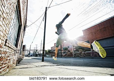 Mixed race athlete jogging on sidewalk View Large Photo Image Stock Image - Mixed race athlete jogging on sidewalk. Fotosearch
