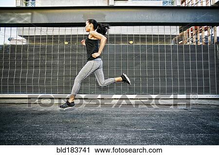 Stock Image - Mixed race athlete running on street. Fotosearch