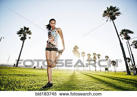 Mixed race athlete stretching in park View Large Photo Image Stock Photography - Mixed race athlete stretching in park. Fotosearch