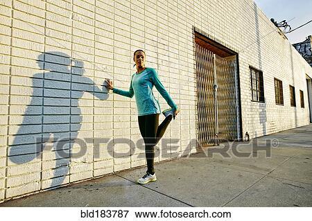 Mixed race athlete stretching on sidewalk View Large Photo Image Stock Photo - Mixed race athlete stretching on sidewalk. Fotosearch
