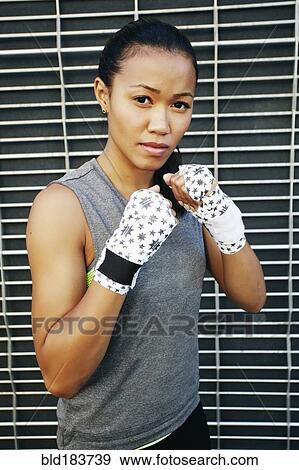 Stock Photo - Mixed race athlete with raised fists. Fotosearch
