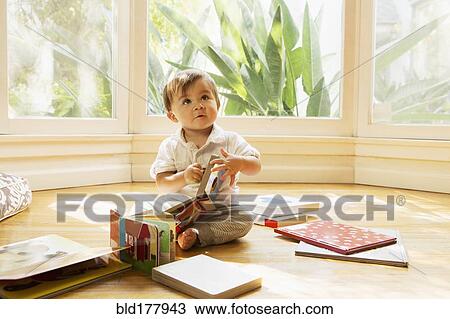 Stock Image - Mixed race baby boy playing on floor. Fotosearch