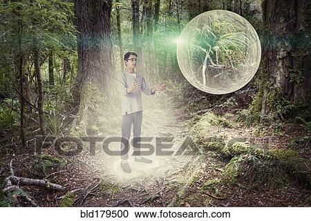 Mixed race boy admiring glowing orb in forest View Large Photo Image Stock Image - Mixed race boy admiring glowing orb in forest. Fotosearch