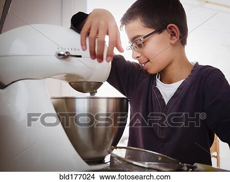 Picture - Mixed race boy baking in kitchen. Fotosearch