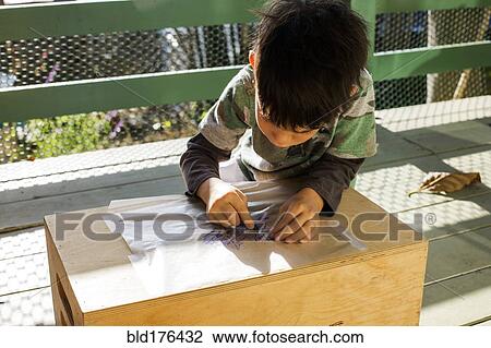 Mixed race boy drawing outdoors View Large Photo Image Stock Image - Mixed race boy drawing outdoors. Fotosearch