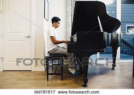 Stock Photo - Mixed race boy playing piano. Fotosearch