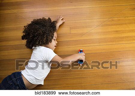 Mixed race boy playing with toy car on floor View Large Photo Image Stock Photo - Mixed race boy playing with toy car on floor. Fotosearch