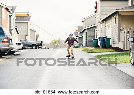 Mixed race boy riding skateboard on street View Large Photo Image Picture - Mixed race boy riding skateboard on street. Fotosearch