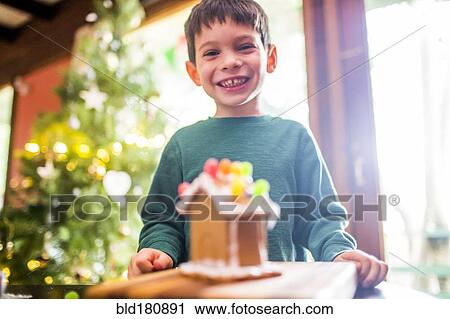 Mixed race boy smiling with gingerbread house View Large Photo Image Stock Image - Mixed race boy smiling with gingerbread house. Fotosearch