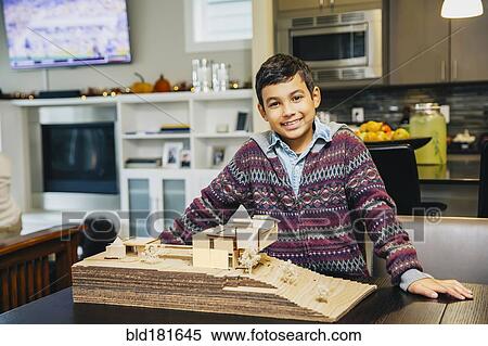 Stock Photography - Mixed race boy smiling with model house. Fotosearch
