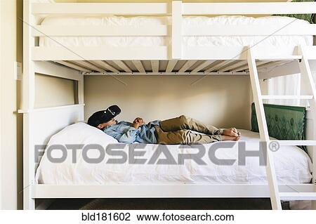 Stock Image - Mixed race boy using virtual reality goggles. Fotosearch