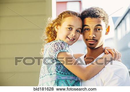 Mixed race brother holding sister outdoors View Large Photo Image Stock Photo - Mixed race brother holding sister outdoors. Fotosearch