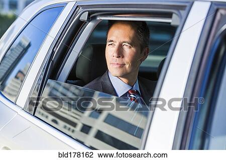 Stock Image - Mixed race businessman sitting in car. Fotosearch