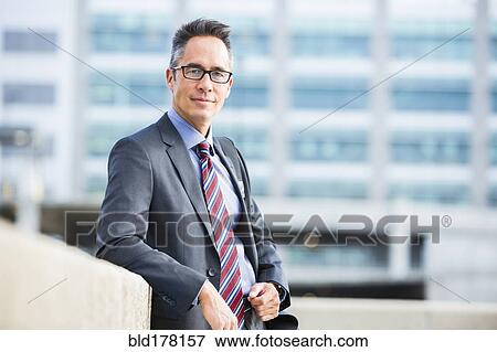 Stock Photo - Mixed race businessman standing outdoors. Fotosearch