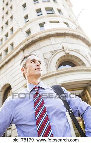 Stock Photo - Mixed race businessman standing outdoors. Fotosearch