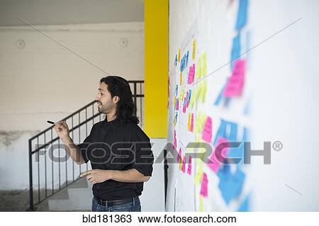 Stock Image - Mixed race businessman talking in office meeting. Fotosearch