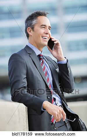 Mixed race businessman talking on cell phone View Large Photo Image Stock Photo - Mixed race businessman talking on cell phone. Fotosearch