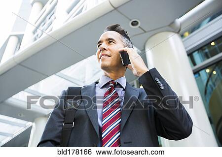 Mixed race businessman talking on cell phone View Large Photo Image Stock Photograph - Mixed race businessman talking on cell phone. Fotosearch