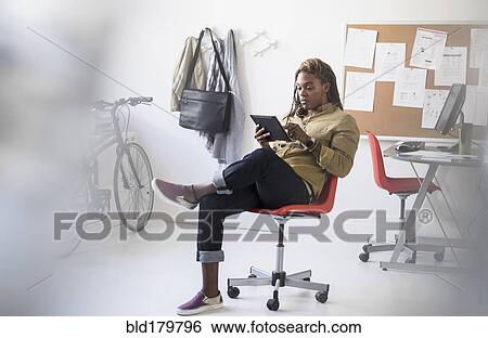 Mixed race businessman using digital tablet in office View Large Photo Image Stock Photograph - Mixed race businessman using digital tablet in office. Fotosearch