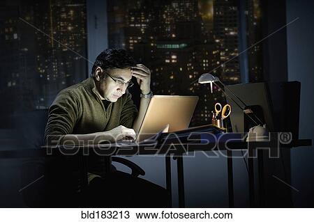 Mixed race businessman working late in office View Large Photo Image Stock Image - Mixed race businessman working late in office. Fotosearch