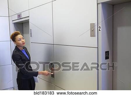 Mixed race businesswoman pressing elevator button View Large Photo Image Stock Image - Mixed race businesswoman pressing elevator button. Fotosearch