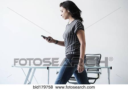 Stock Photo - Mixed race businesswoman using cell phone. Fotosearch
