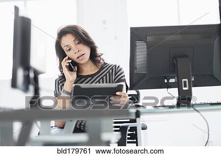 Stock Image - Mixed race businesswoman using digital tablet. Fotosearch