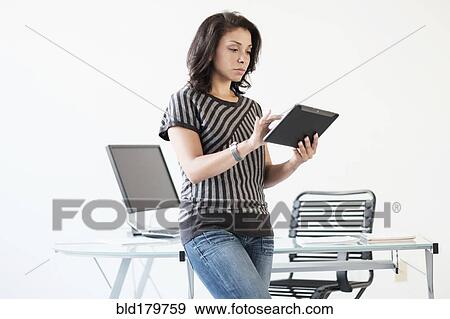 Stock Photo - Mixed race businesswoman using digital tablet. Fotosearch