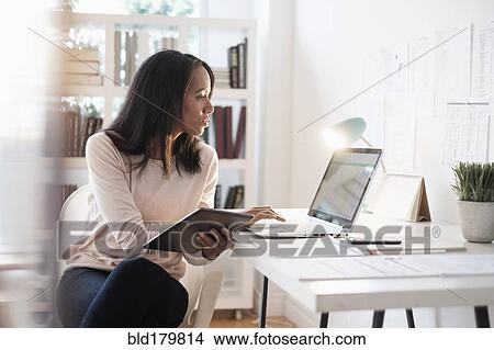 Mixed race businesswoman using laptop View Large Photo Image Picture - Mixed race businesswoman using laptop. Fotosearch