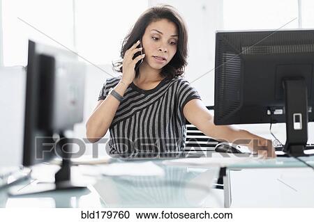 Mixed race businesswoman working at desk View Large Photo Image Stock Image - Mixed race businesswoman working at desk. Fotosearch