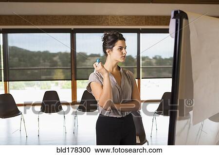 Stock Image - Mixed race businesswoman working in meeting room. Fotosearch