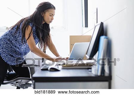 Stock Photo - Mixed race businesswoman working in office. Fotosearch