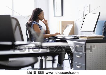 Stock Photography - Mixed race businesswoman working in office. Fotosearch