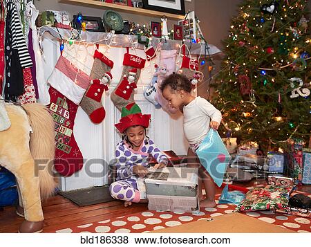 Mixed race children opening Christmas gifts View Large Photo Image Stock Photo - Mixed race children opening Christmas gifts. Fotosearch