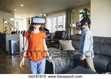 Mixed race children using virtual reality goggles in living room View Large Photo Image Stock Photo - Mixed race children using virtual reality goggles in living room. Fotosearch