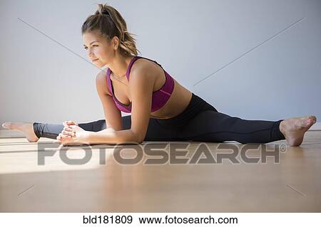Stock Photo - Mixed race dancer stretching in studio. Fotosearch