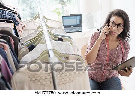 Stock Image - Mixed race designer working in studio. Fotosearch