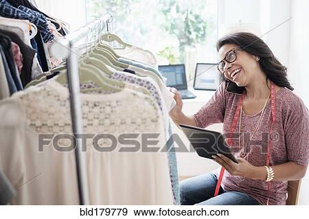 Stock Photo - Mixed race designer working in studio. Fotosearch