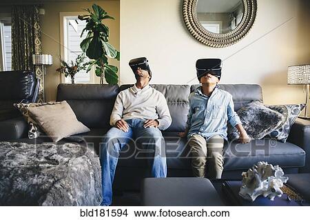 Mixed race father and daughter using virtual reality goggles View Large Photo Image Picture - Mixed race father and daughter using virtual reality goggles. Fotosearch