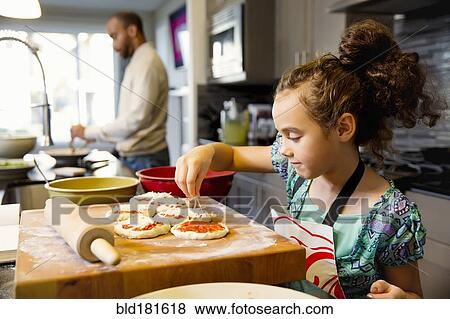 Mixed race girl cooking in kitchen View Large Photo Image Stock Photo - Mixed race girl cooking in kitchen. Fotosearch