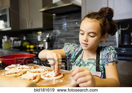 Stock Photo - Mixed race girl cooking in kitchen. Fotosearch