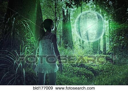 Stock Photo - Mixed race girl discovering glowing sphere in forest. Fotosearch