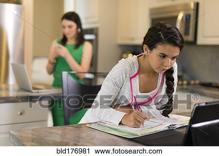 Stock Image - Mixed race girl doing homework. Fotosearch