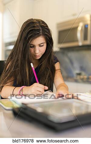 Stock Photo - Mixed race girl doing homework. Fotosearch