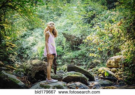 Mixed race girl exploring stream View Large Photo Image Stock Photo - Mixed race girl exploring stream. Fotosearch