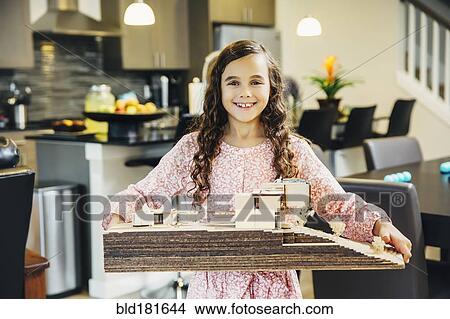 Mixed race girl holding model house View Large Photo Image Picture - Mixed race girl holding model house. Fotosearch