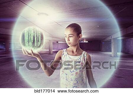 Picture - Mixed race girl holding sphere. Fotosearch
